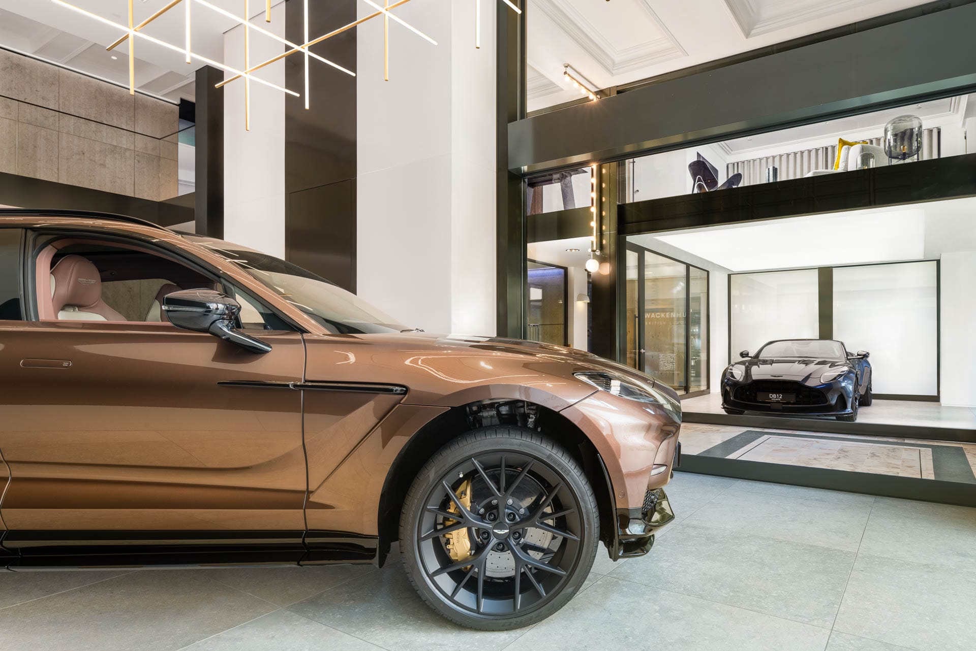 Aston Martin DBX in Bronze und DBS Superleggera in Schwarz im exklusiven Showroom in Baden-Baden
