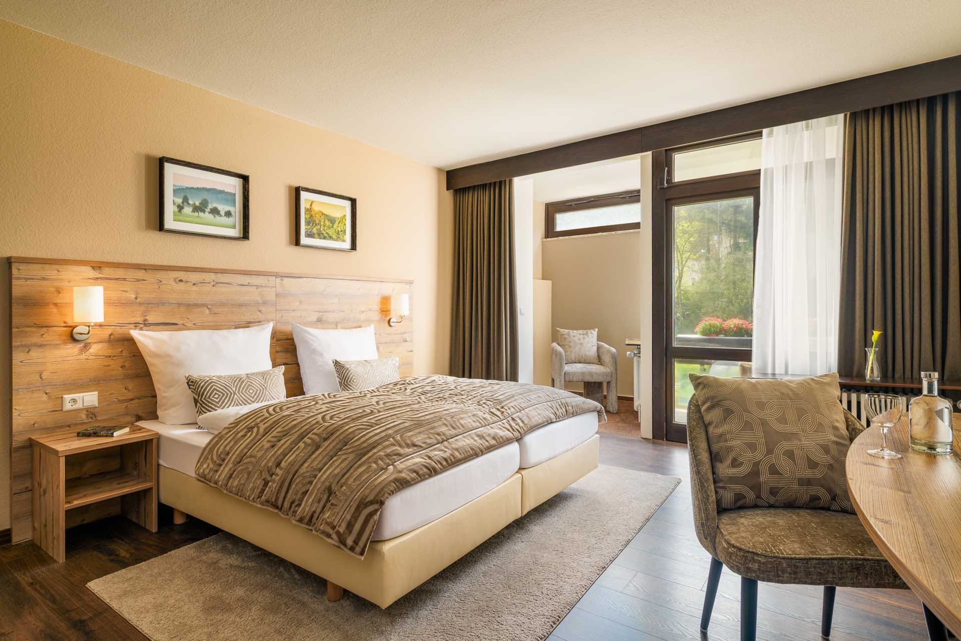 Komfortables Doppelzimmer mit Holzdekor, großen Fenstern und Naturblick im Hotel Luisenpark Bad Bergzabern