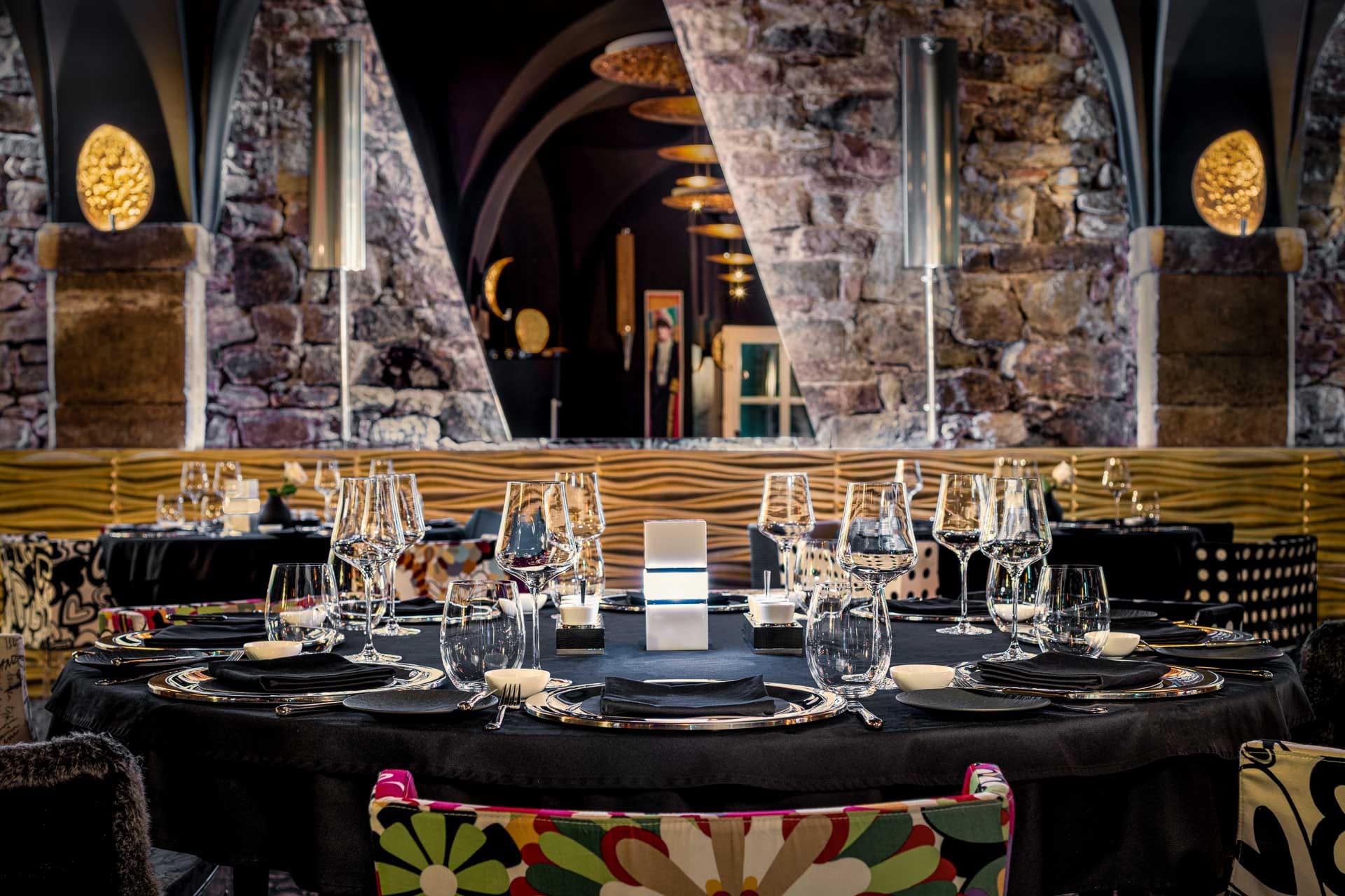 Fein gedeckter Tisch im Restaurant Nigrum Baden-Baden mit edlem Glas- und Besteckarrangement vor historischer Sandsteinmauer