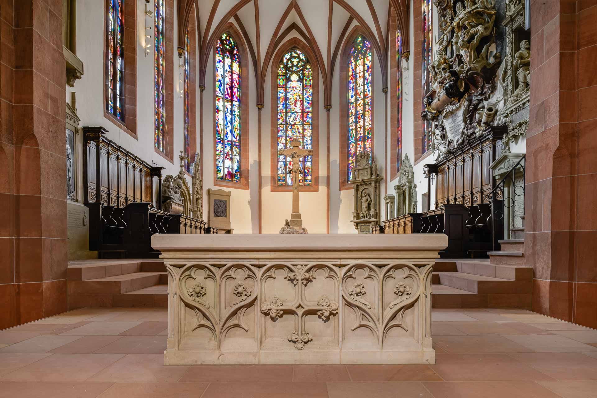 Gotischer Altar vor farbigen Chorfenstern in der Stiftskirche Baden-Baden