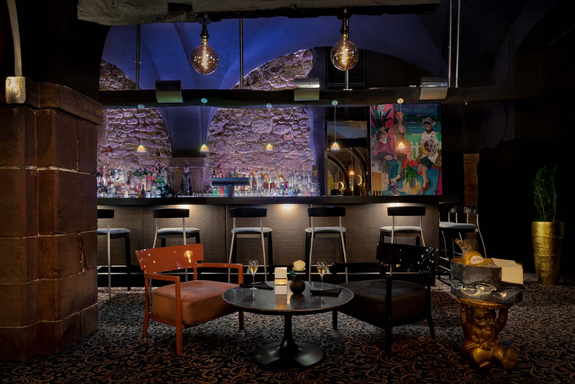 Bar und Lounge im Restaurant Nigrum Baden-Baden mit stimmungsvoller Beleuchtung, Natursteinwand und elegantem Interieur