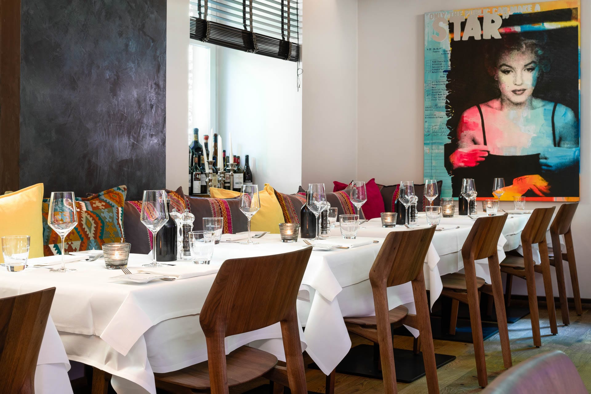 Modernes Restaurant Rizzi in Baden-Baden mit farbenfroher Wandkunst und elegant gedecktem Tisch