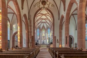 Innenraum der Stiftskirche Liebfrauen in Baden-Baden mit Blick auf den Altar und die bunten Glasfenster