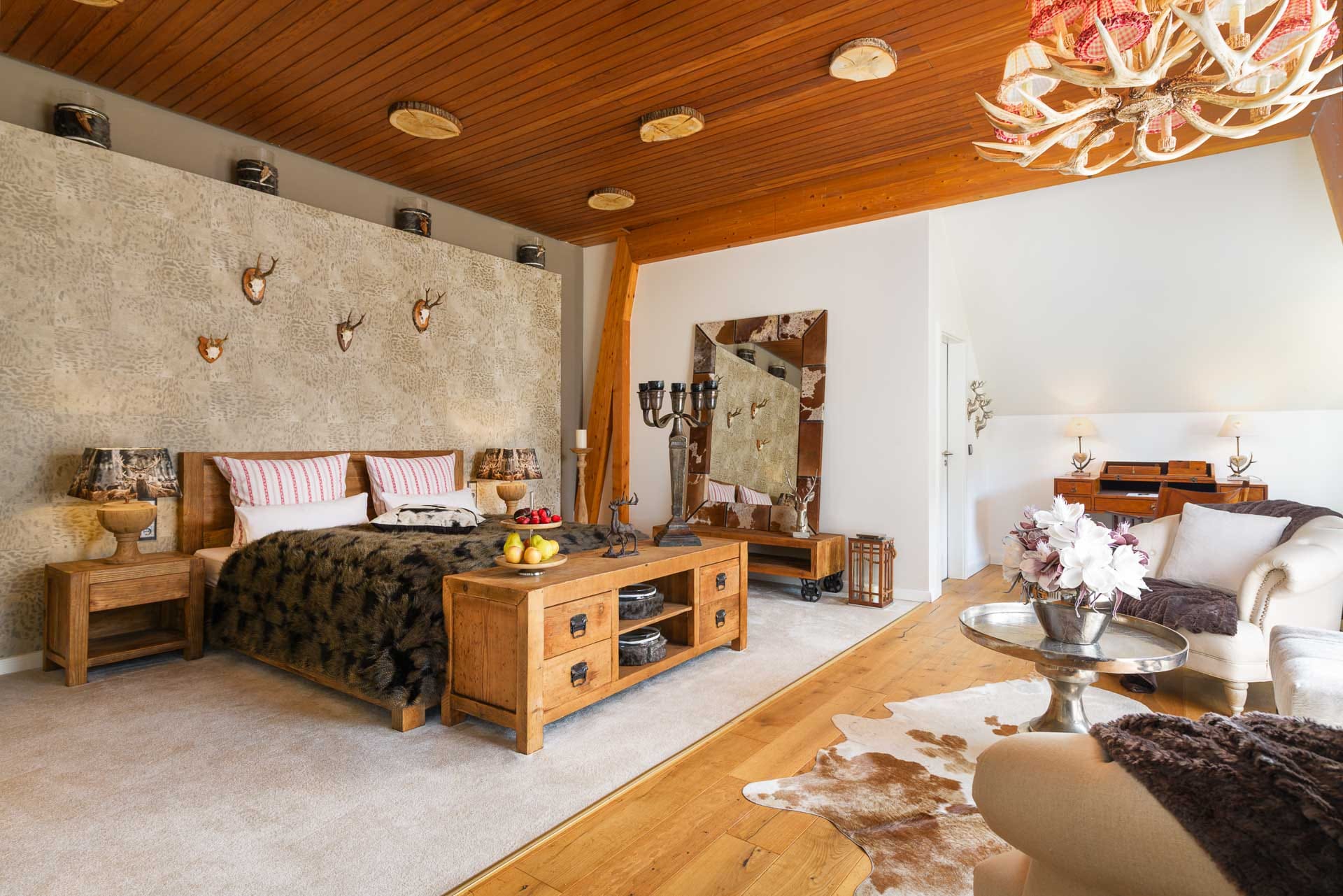 Rustikale Suite mit Holzmöbeln, Geweih-Lampe und alpinem Design im Hotel Luise Bad Bergzabern