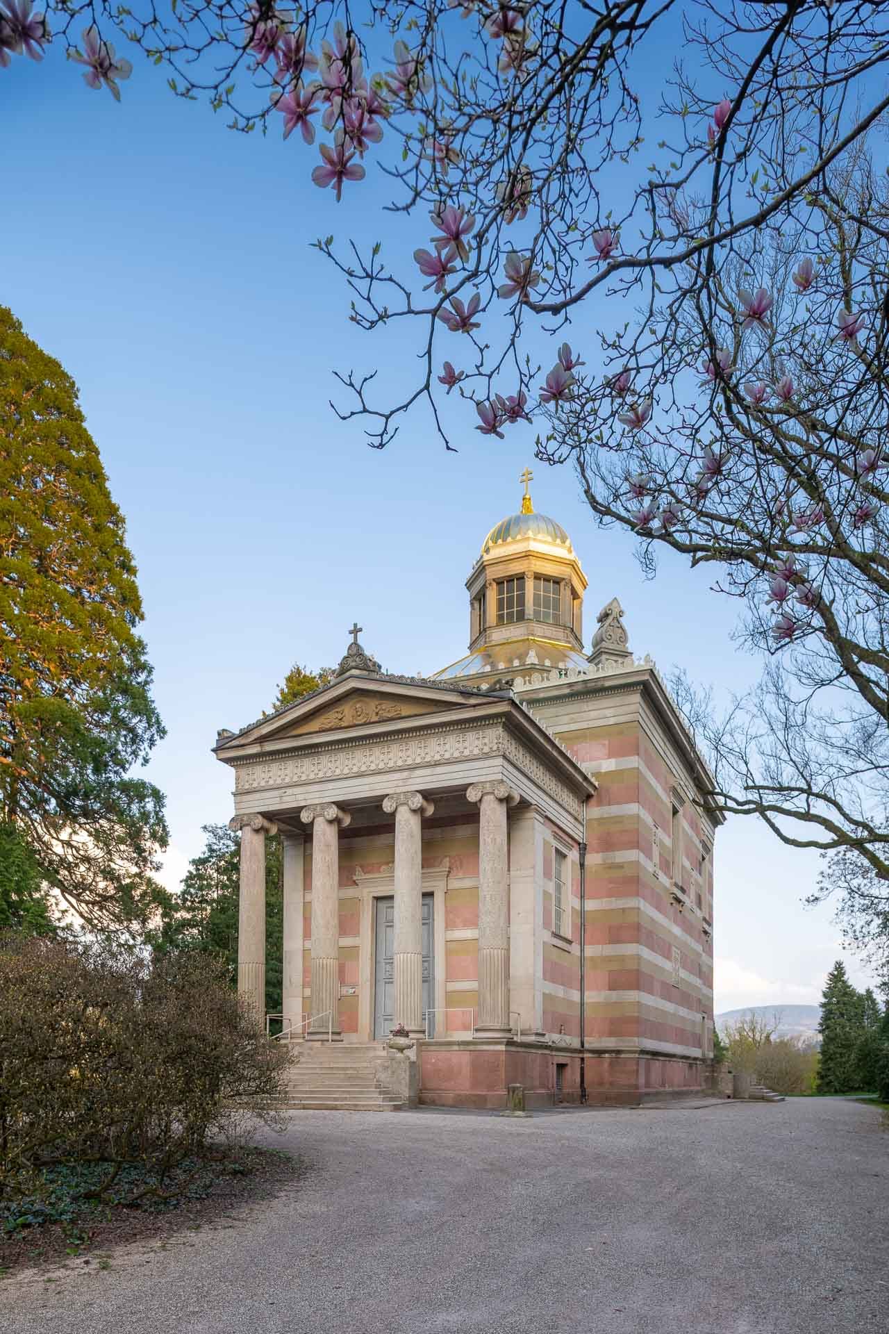 Außenansicht der Stourdza-Kapelle in Baden-Baden mit goldener Kuppel und blühenden Magnolien