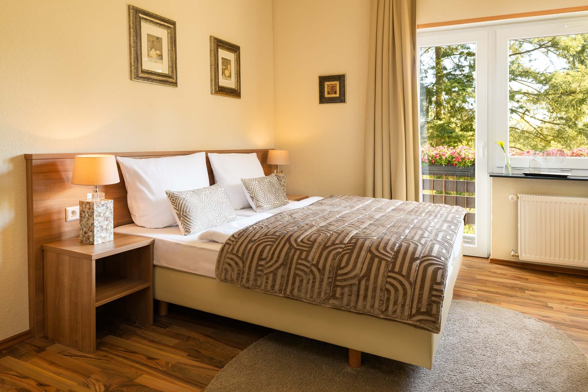 Gemütliches Gästezimmer im Hotel Luisenpark mit Doppelbett, Holzmöbeln und Blick ins Grüne